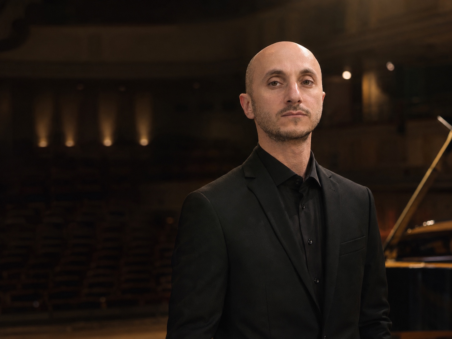 Tigran Matinyan standing in a concert hall